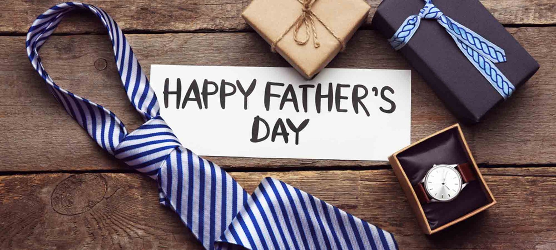 Happy father's day Inschrift auf einem weißen Blatt gelegt auf einem Holzkasten zwischen der Krawatte und den Geschenken